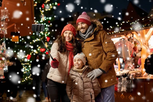 Happy family taking selfie at christmas market — Stock Photo, Image