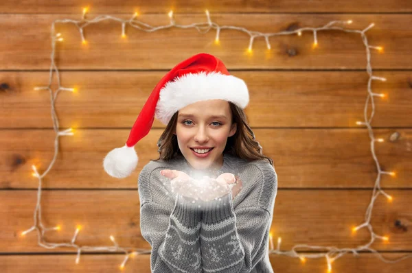 Woman in christmas sweater holding magic dust — Stock Photo, Image