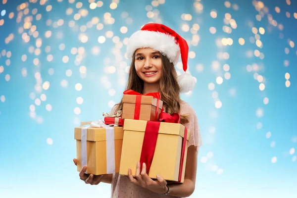 Tonårstjej i tomte hatt med julklapp — Stockfoto