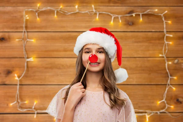 Happy teenage girl in santa hat on christmas — Stock Photo, Image