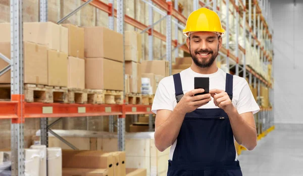 Χαρούμενος εργάτης με smartphone στην αποθήκη — Φωτογραφία Αρχείου