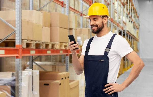 Trabalhador masculino feliz com smartphone no armazém — Fotografia de Stock