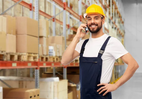 Trabalhador masculino chamando no smartphone no armazém — Fotografia de Stock