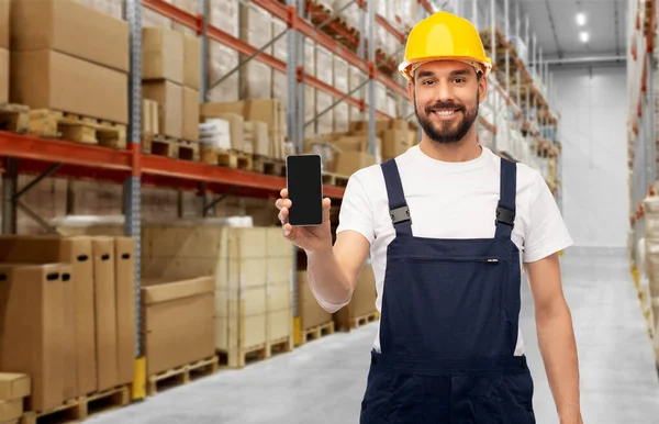 Glücklicher männlicher Arbeiter mit Smartphone im Lager — Stockfoto