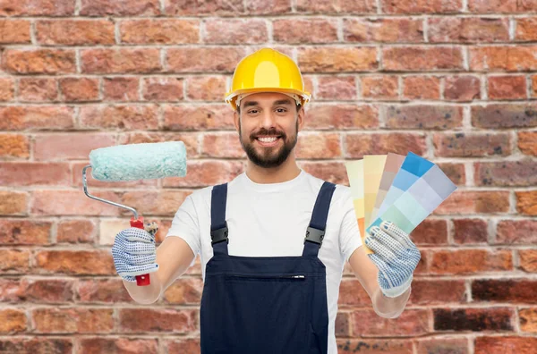 Male builder with paint roller and color palettes — Stock Photo, Image
