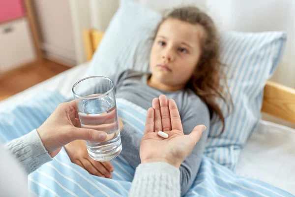 Mother giving medicine to sick little daughter — Stock Photo, Image