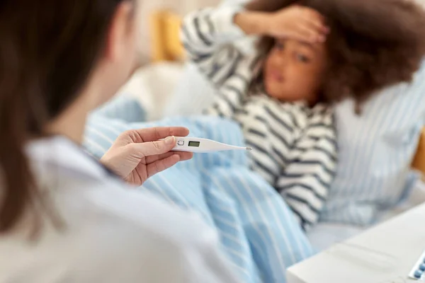 Médecin mesure la température des filles malades — Photo
