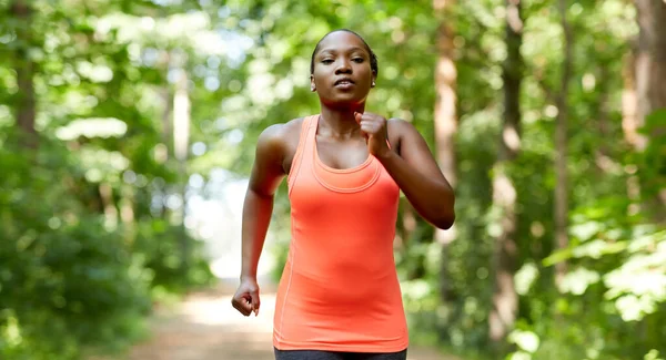 Young african american woman running in forest — Stock Photo, Image