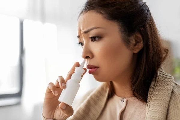 Malato asiatico donna con nasale spray medicina a casa — Foto Stock