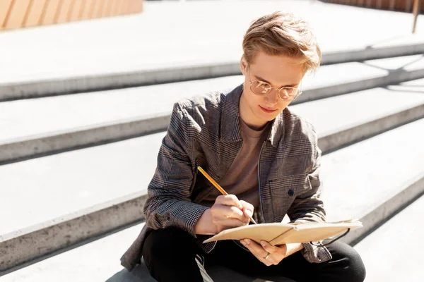 Fiatal férfi notebook vagy vázlatfüzet a városban — Stock Fotó