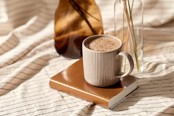 Xícara de café no livro e flores secas em vasos — Fotografia de Stock