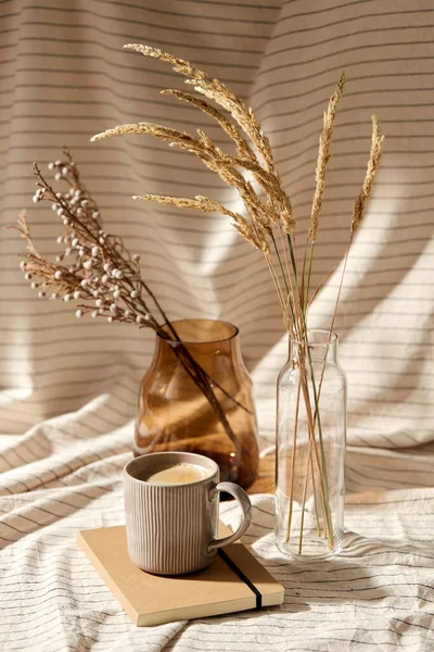 Tasse Kaffee, Tagebuch und getrocknete Blumen in Vasen — Stockfoto