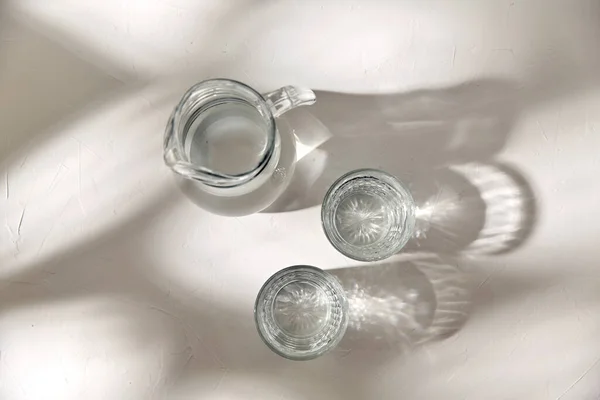 白い背景に水を入れた2つのメガネとジャグ — ストック写真
