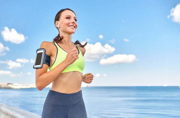 Mujer con auriculares y smartphone funcionando — Foto de Stock