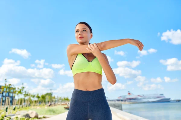 Genç bir kadın deniz kenarında spor yapıyor. — Stok fotoğraf