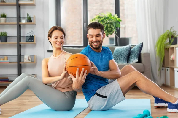 Feliz pareja haciendo ejercicio con la pelota en casa —  Fotos de Stock