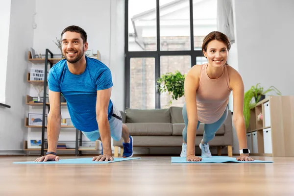 Feliz pareja haciendo ejercicio en casa —  Fotos de Stock