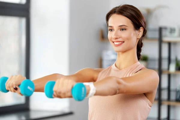 Mulher feliz com halteres exercitando em casa — Fotografia de Stock