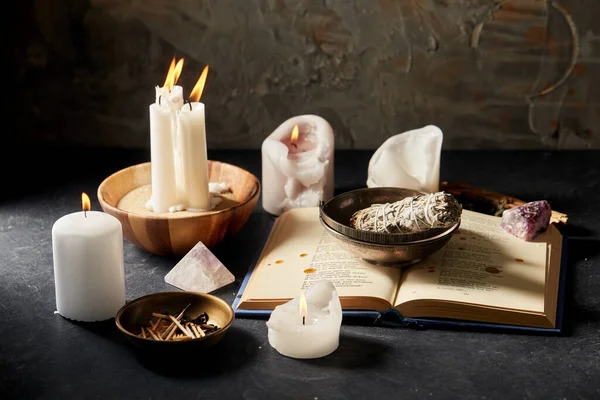 Libro magico, salvia, candele accese e bastone rituale — Foto Stock