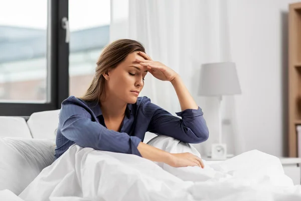 Schläfrige Frau sitzt zu Hause im Bett — Stockfoto