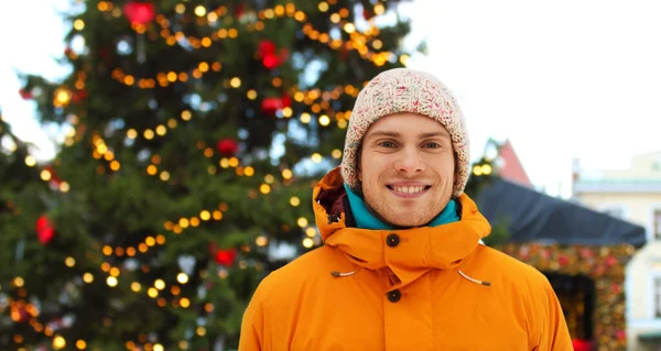 Junger Mann glücklich über Weihnachtsmarkt-Hintergrund — Stockfoto