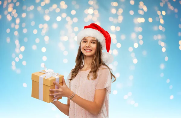 Adolescente en sombrero de santa con regalo de Navidad —  Fotos de Stock
