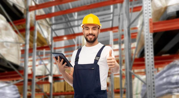 Loader with tablet pc shows thumbs up at warehouse — стоковое фото