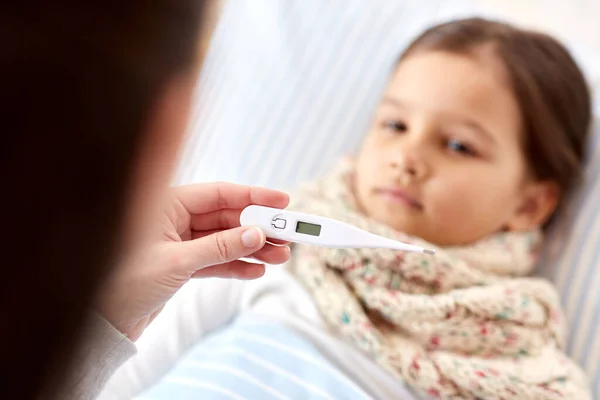 Mãe medir a temperatura da filha doente — Fotografia de Stock