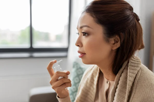 Sjuk asiatisk kvinna som använder oral spraymedicin i hemmet — Stockfoto