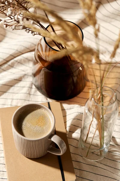 Xícara de café, diário e flores secas em vasos — Fotografia de Stock