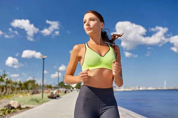 Mujer joven corriendo a lo largo del paseo marítimo —  Fotos de Stock