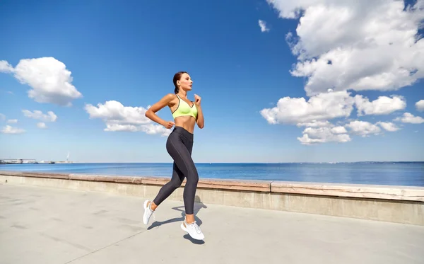 Giovane donna che corre lungo il lungomare — Foto Stock