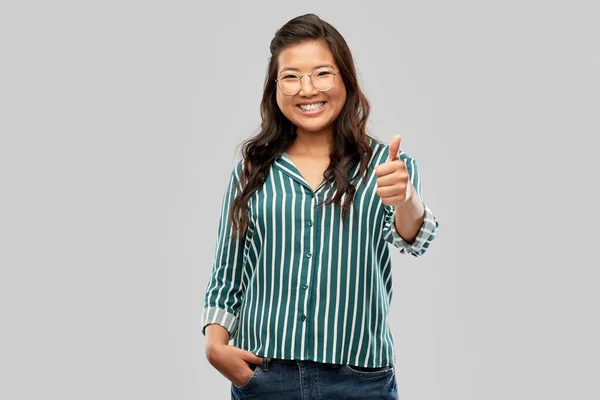 Glad asiatisk kvinna i glasögon visar tummen upp — Stockfoto