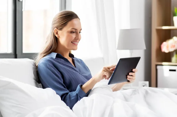 집 침실에서 침대에 태블릿 PC 를 갖고 있는 젊은 여자 — 스톡 사진