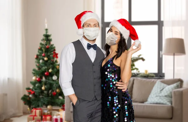 Couple in protective masks at home on christmas — Stock Photo, Image