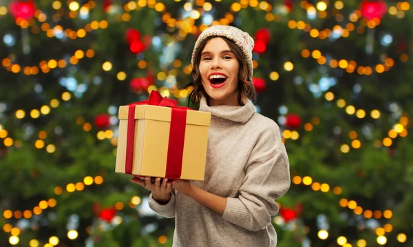 Ευτυχισμένη νεαρή γυναίκα που κρατάει χριστουγεννιάτικο δώρο — Φωτογραφία Αρχείου