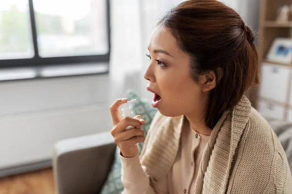 Enfermo asiático mujer usando oral spray medicina en casa — Foto de Stock