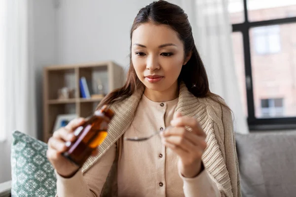 Sjuk asiatisk kvinna som tar medicin hemma — Stockfoto