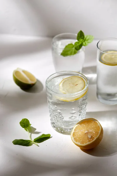 Szklanki z wodą cytrynową i miętą pieprzową na stole — Zdjęcie stockowe
