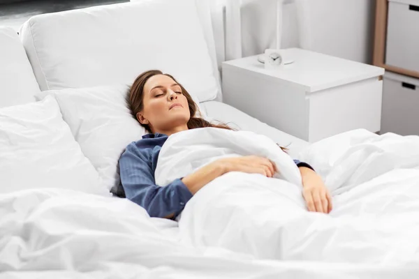 Mujer joven durmiendo en la cama en casa —  Fotos de Stock