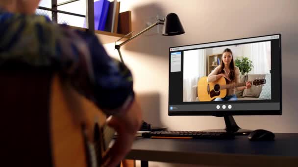 Мужчина учится играть на гитаре онлайн дома — стоковое видео