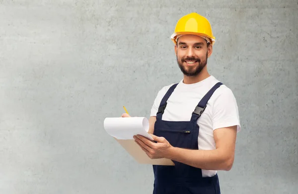 Trabalhador masculino ou construtor em capacete com prancheta — Fotografia de Stock