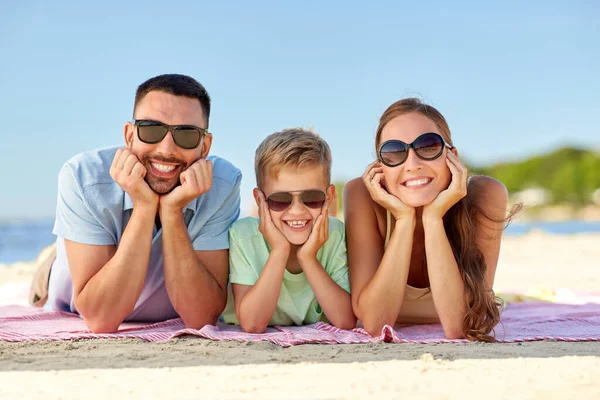 Familia feliz acostada en la playa de verano — Foto de Stock