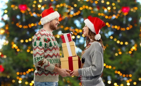 Casal feliz em camisolas de Natal com presentes — Fotografia de Stock