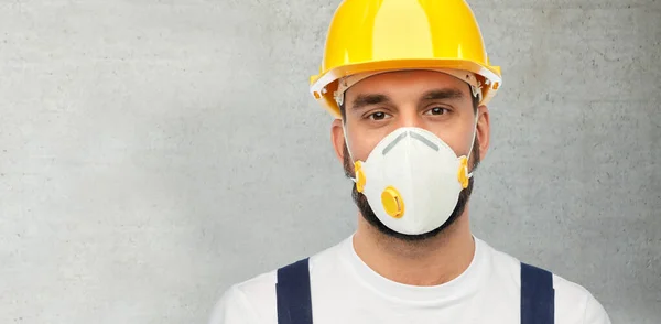 Мужчина или строитель в шлеме и респираторе — стоковое фото