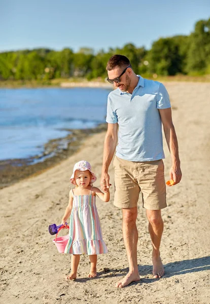 Glücklicher Vater spaziert mit kleiner Tochter am Strand — Stockfoto