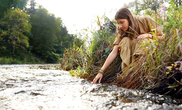 Женщина или ведьма, совершающая магический ритуал на реке — стоковое фото
