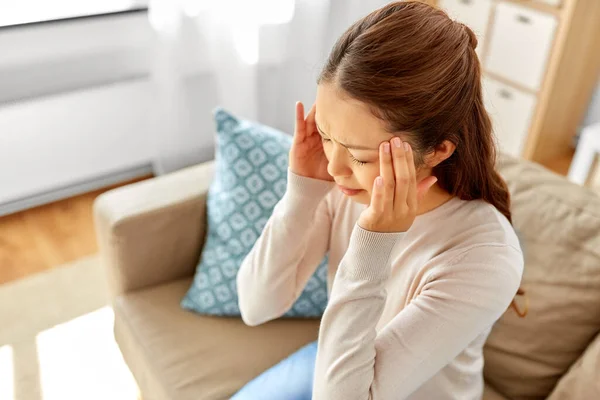Хвора азіатська жінка має головний біль вдома — стокове фото
