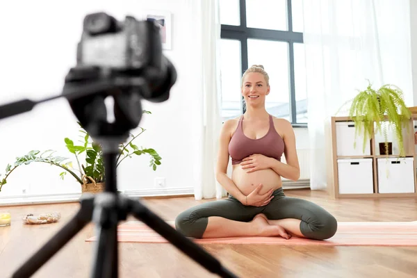 Mujer embarazada o bloguera de yoga con cámara en casa — Foto de Stock