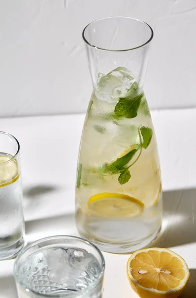 Vasos con agua de limón y menta sobre la mesa — Foto de Stock